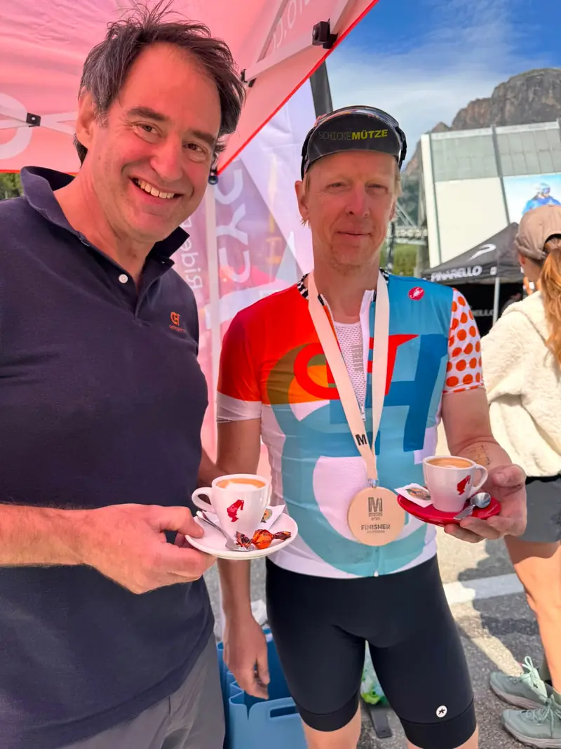 Two riders with espresso cups after a Gran Fondo finish